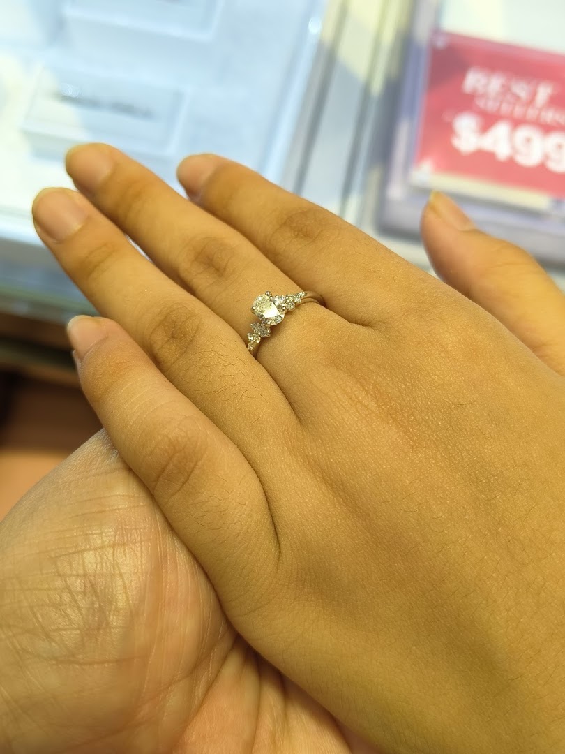 A hand models a sparkling diamond ring, showcasing exquisite jewelry from SK Gold.