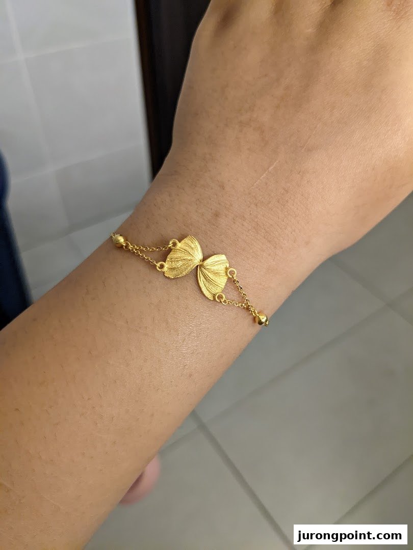 A person's arm adorned with a delicate gold butterfly bracelet from SK Gold.