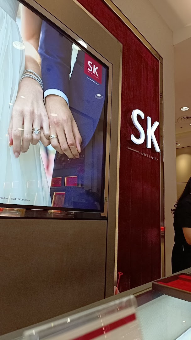 A digital display showcasing wedding rings and the SK Jewellery logo inside the store.