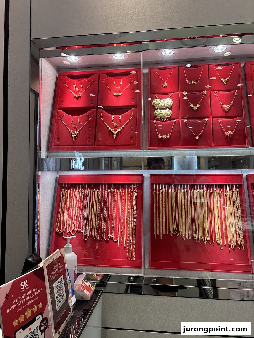 A display case inside SK Gold showcasing a variety of intricate gold necklaces and pendants on red velvet.
