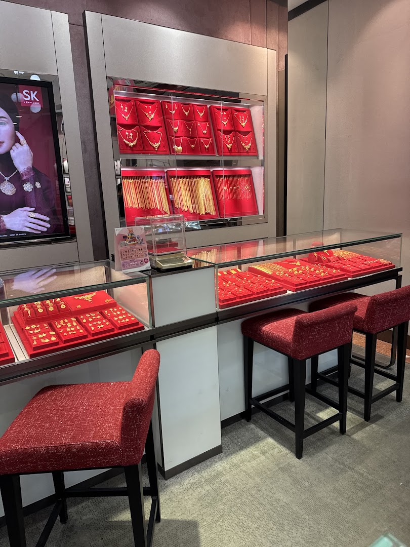 Interior view of SK Gold jewelry shop showcasing gold necklaces, bracelets, and rings in display cases.