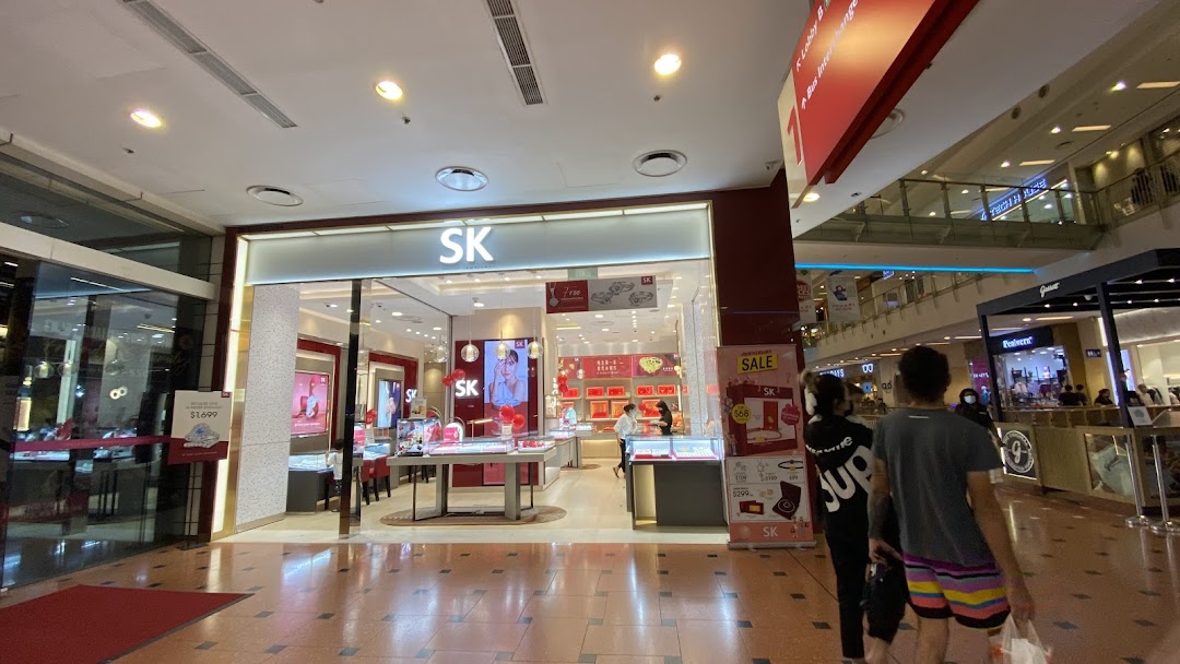 The brightly lit storefront of SK Jewellery, showcasing dazzling displays within a bustling mall environment.