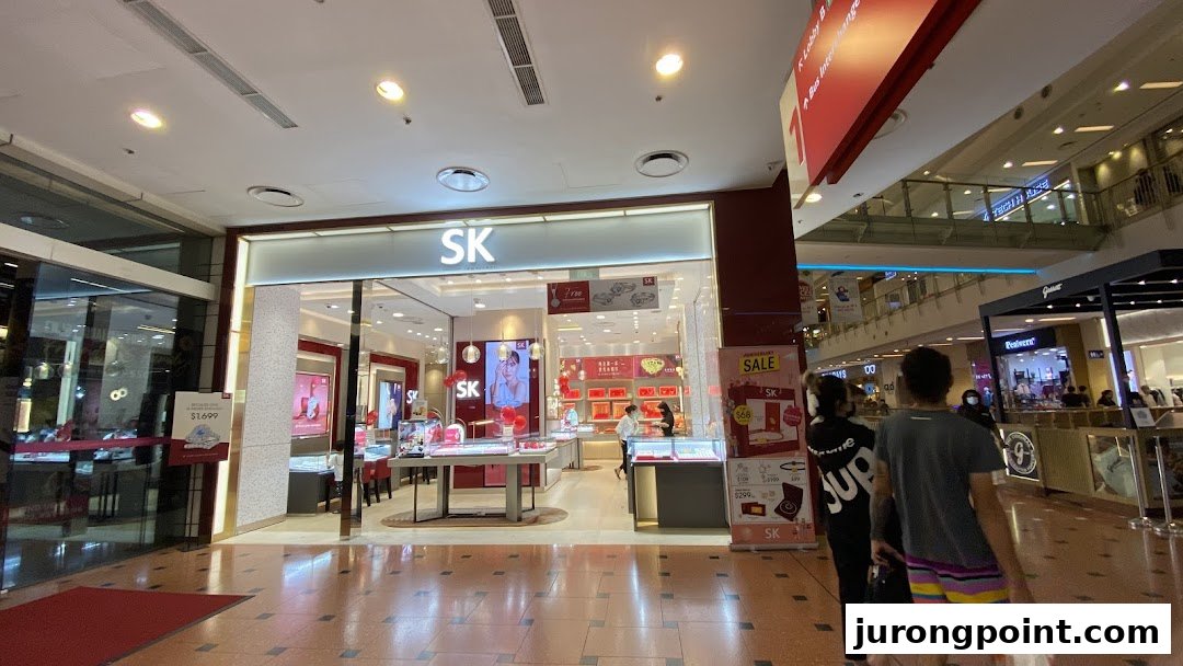 The brightly lit storefront of SK Jewellery, showcasing dazzling displays within a bustling mall environment.
