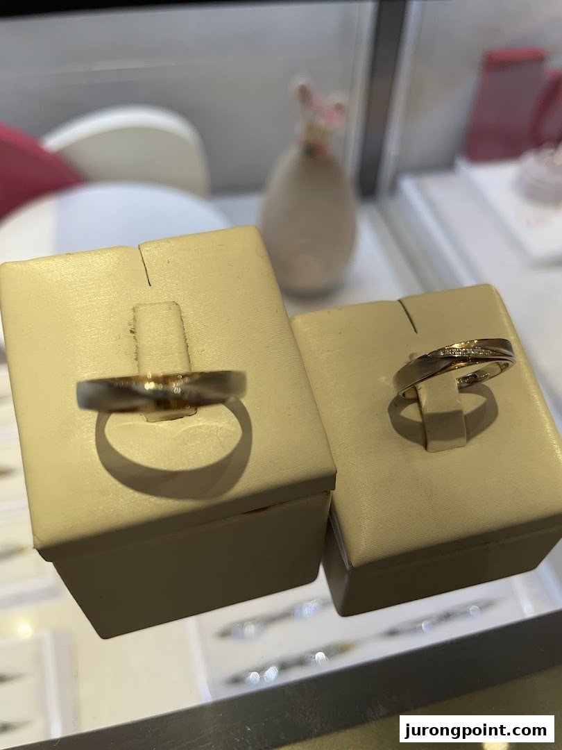 Two elegant rings, possibly wedding bands, displayed on stands in a jewellery shop.