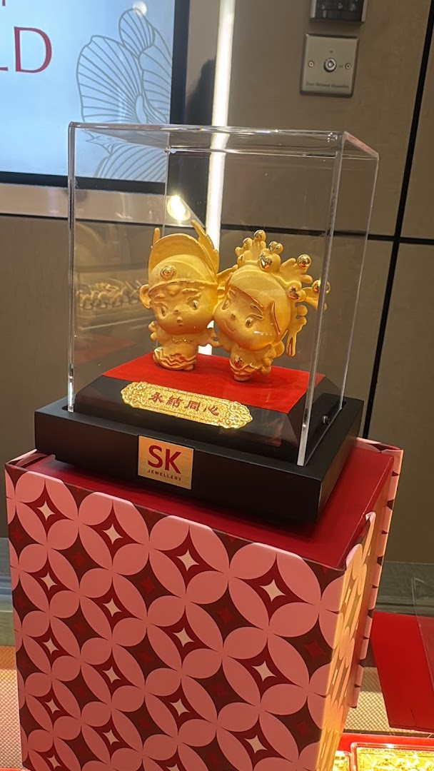 Golden figurines in a display case, showcasing a product from SK Jewellery.