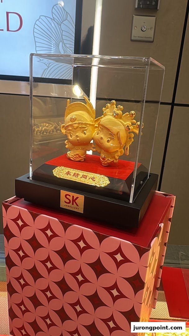 Golden figurines in a display case, showcasing a product from SK Jewellery.