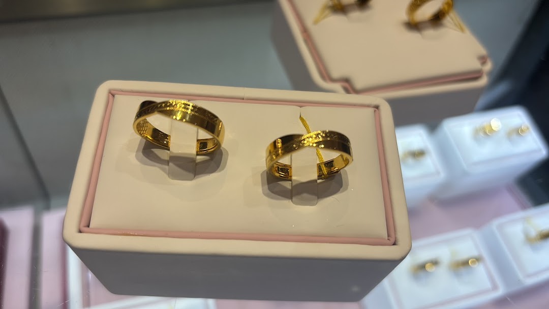 Two elegant gold rings displayed prominently in a jewelry store showcase.