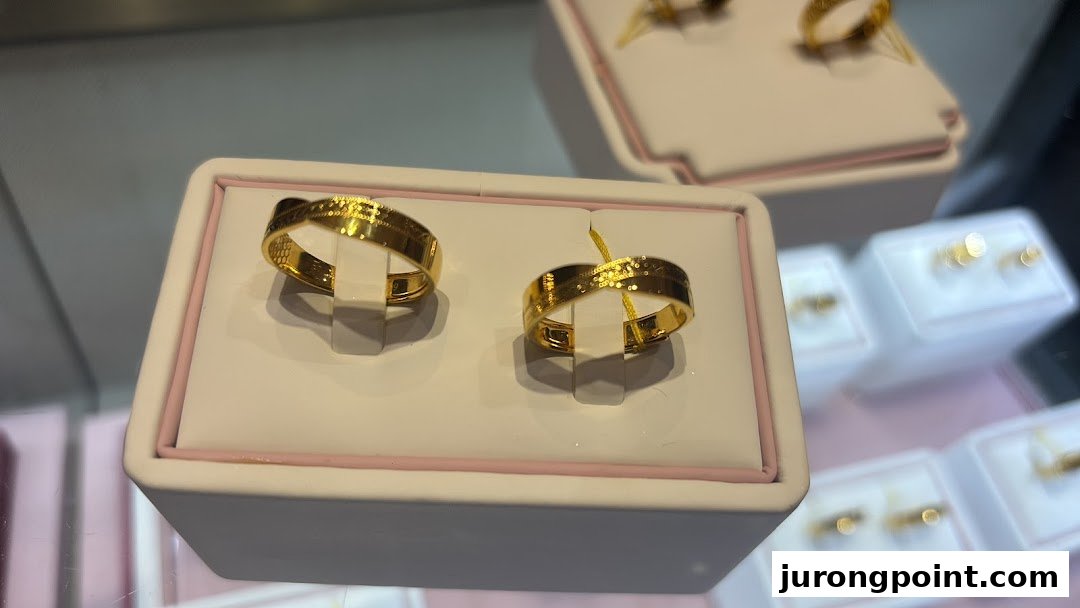 Two elegant gold rings displayed prominently in a jewelry store showcase.