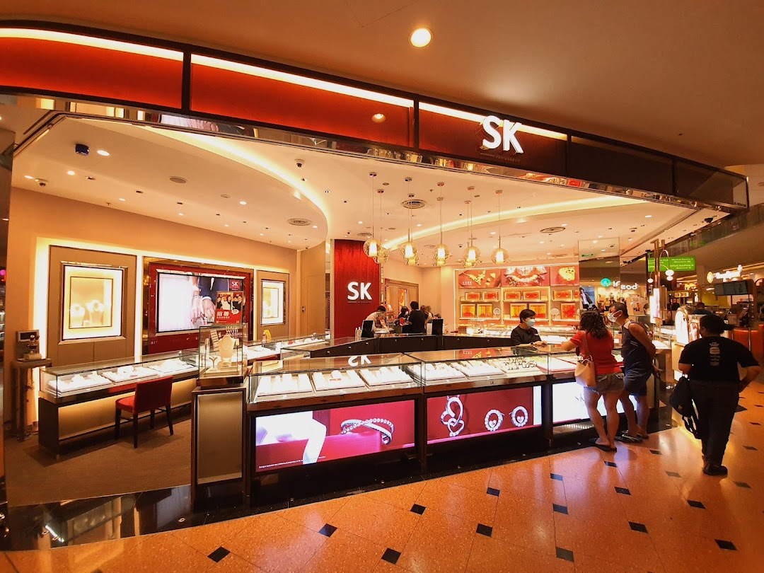 Interior view of SK Jewellery showcasing display cases with customers browsing exquisite jewelry.