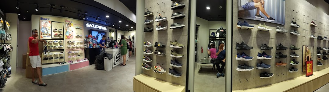Interior view of a Skechers shoe store, showcasing various footwear on display and customers browsing.