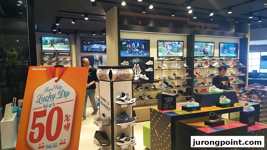 Interior view of a Skechers store showcasing various footwear, digital displays, and a promotional offer.