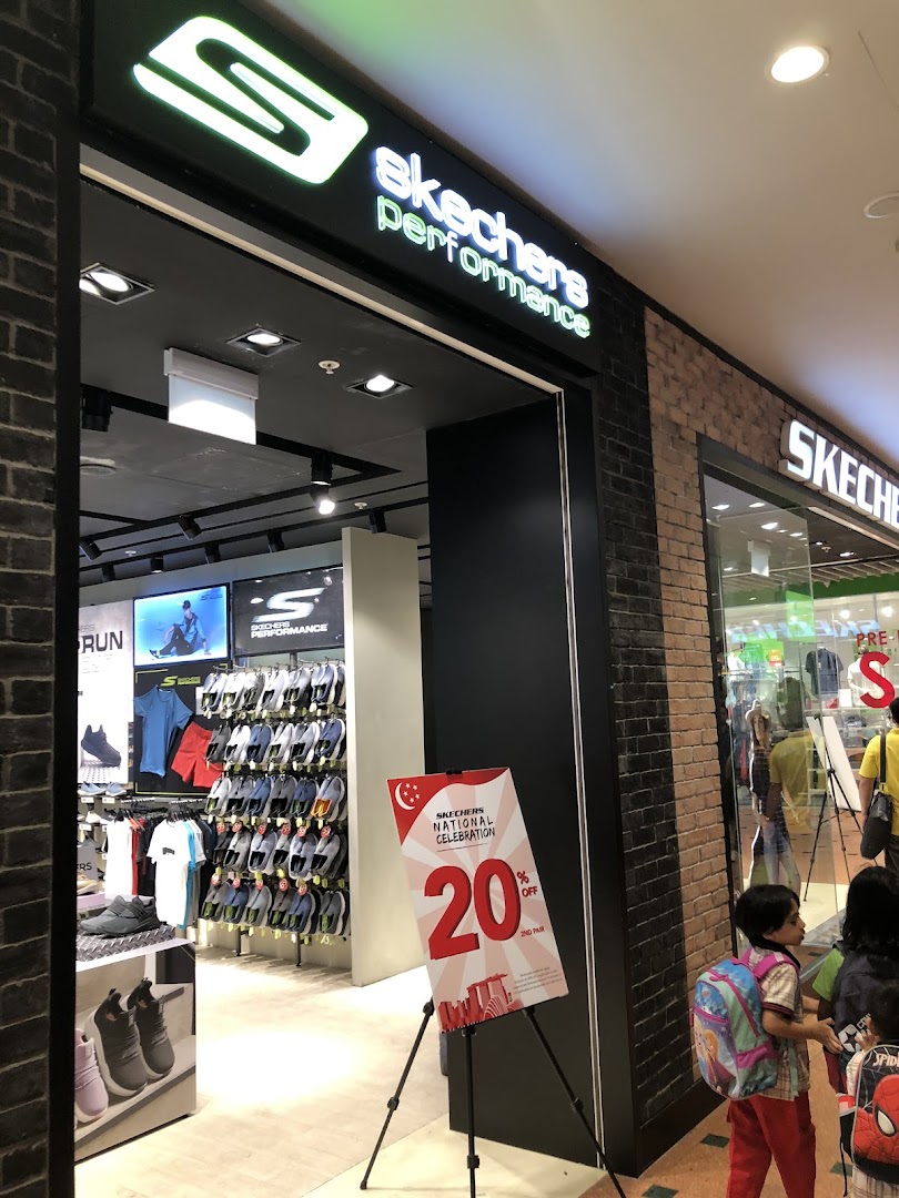 The entrance of a Skechers Performance store showcasing footwear and apparel, with a promotional sign.