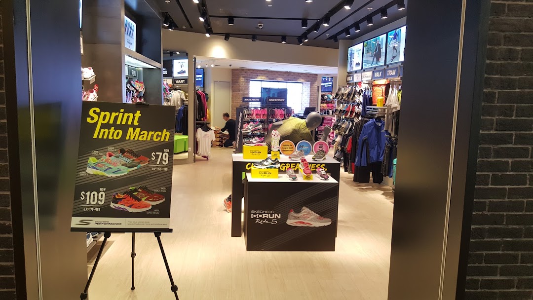 The entrance of a Skechers store showcasing athletic footwear and a promotional sign.