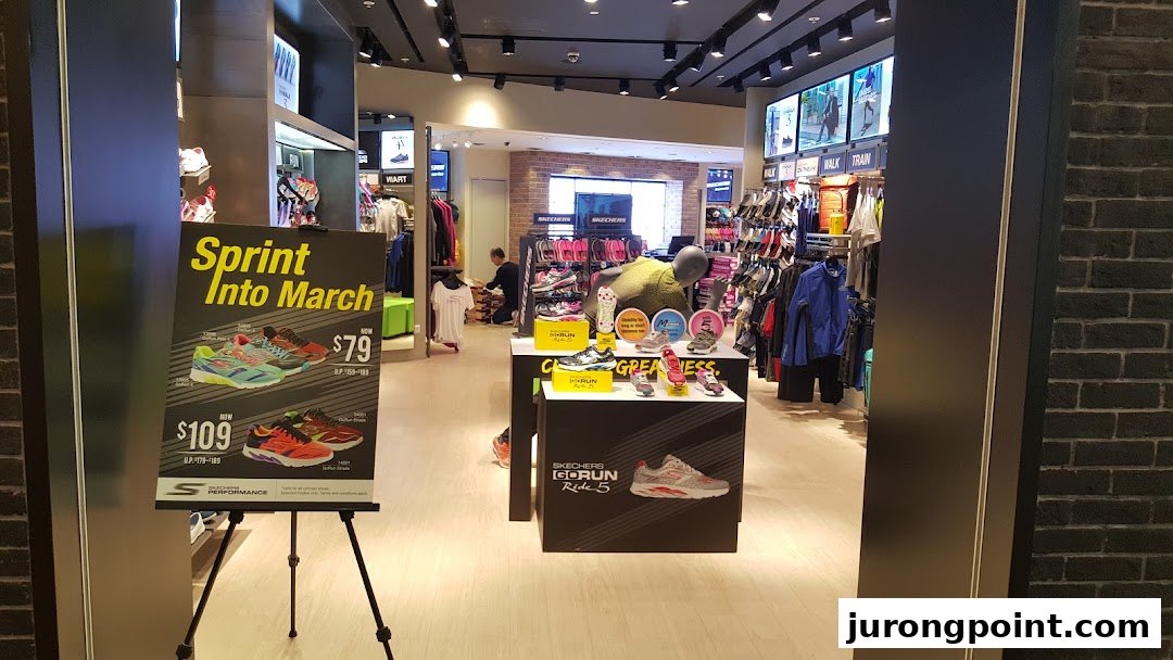 The entrance of a Skechers store showcasing athletic footwear and a promotional sign.
