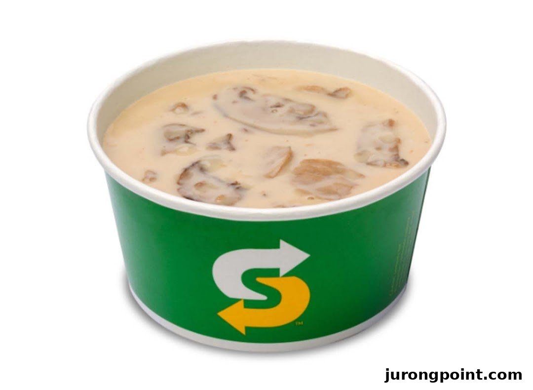 A cup of creamy mushroom soup with the Subway logo on a white background.