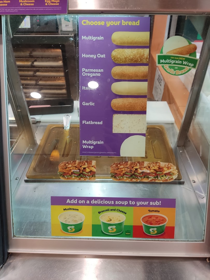 A Subway display case showcasing bread options, wraps, and soup choices.