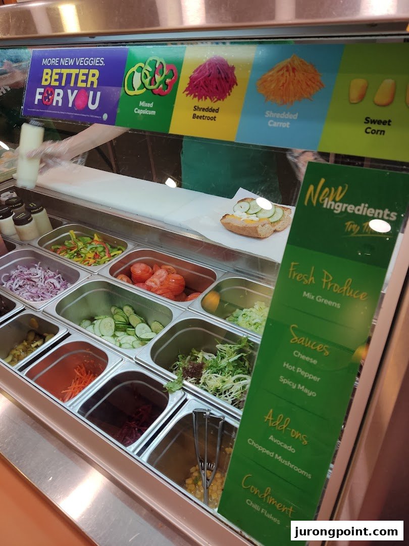 A vibrant Subway counter showcasing fresh vegetables, sauces, and add-ons for custom sandwich creation.