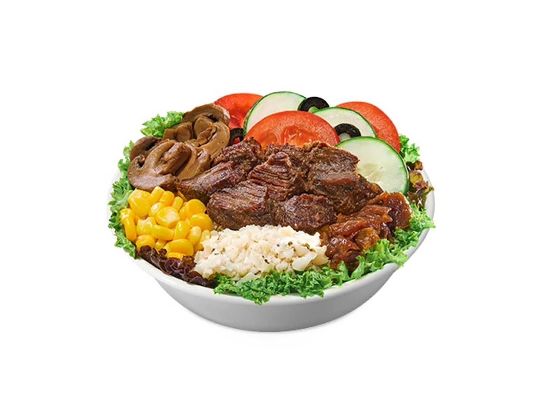A vibrant salad bowl featuring beef, mushrooms, corn, tomatoes, cucumbers, and lettuce.