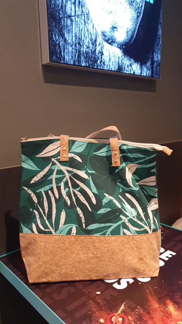 A stylish green and white leaf-patterned tote bag with a cork base, likely from The Body Shop.