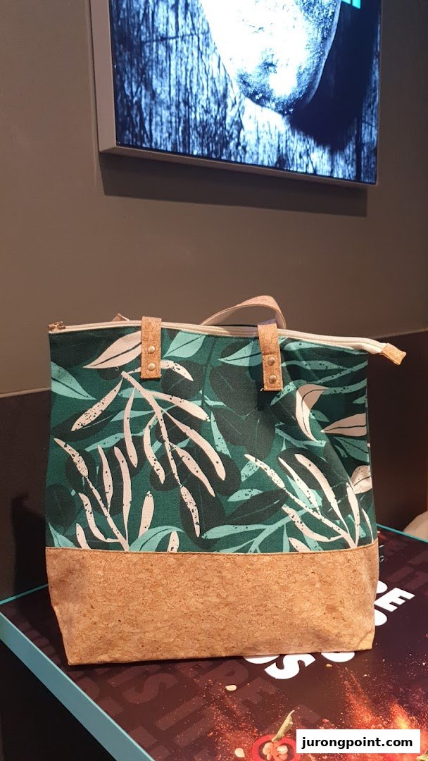 A stylish green and white leaf-patterned tote bag with a cork base, likely from The Body Shop.