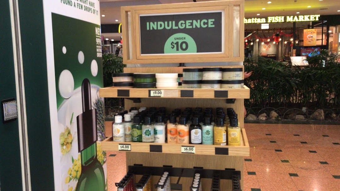 A retail display from The Body Shop featuring skincare products and an 'Indulgence Under $10' promotion.