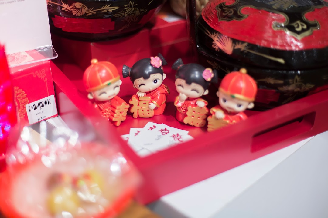 Close-up of charming Chinese wedding figurines and traditional items displayed on a red tray.