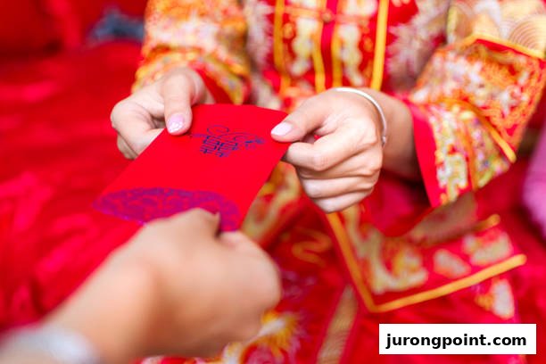 Hands exchanging a red envelope with 'double happiness' symbol, person in traditional Chinese wedding attire.