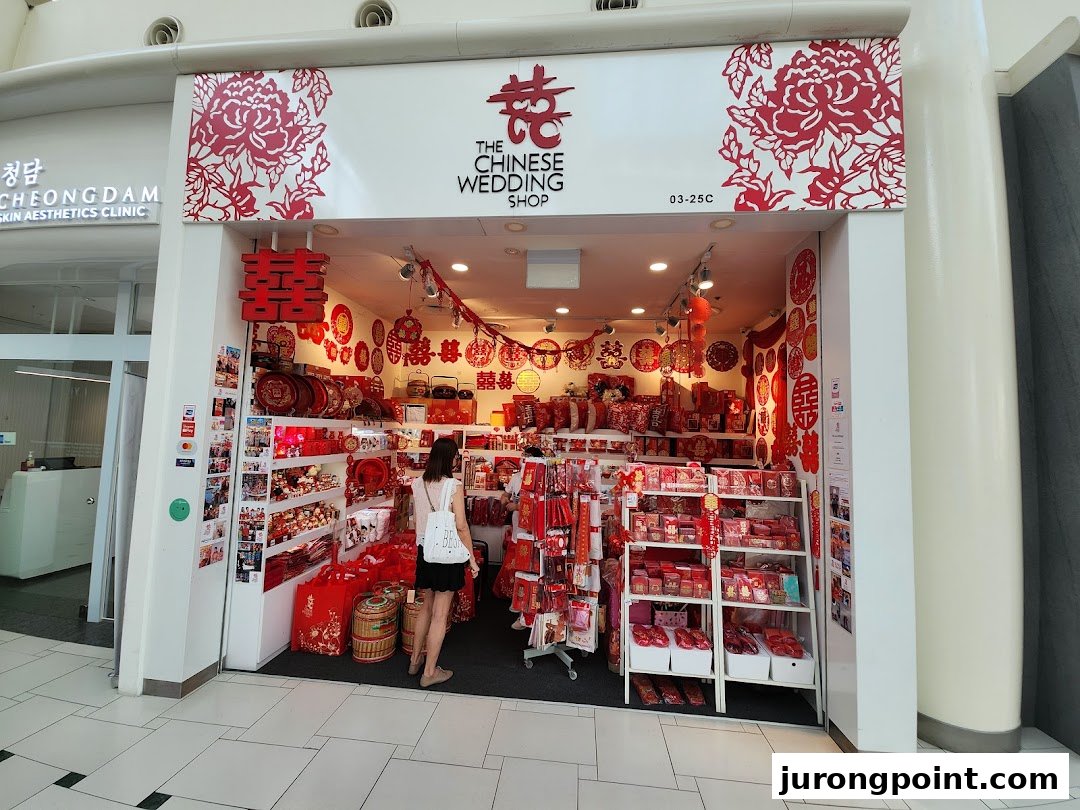 The shop front of 'The Chinese Wedding Shop' displaying traditional red wedding items, with a customer browsing inside.
