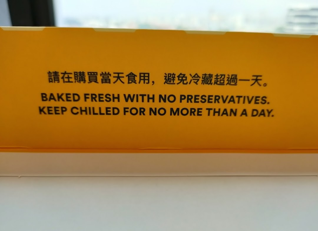 A close-up of a yellow sign or packaging with instructions about product freshness and storage.