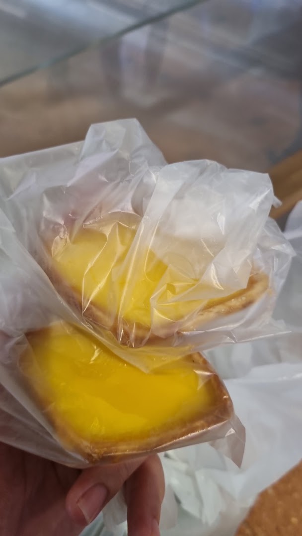 Two delicious Tong Heng egg tarts, individually wrapped and ready to enjoy.