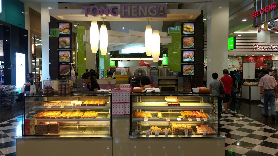 A bustling Tong Heng bakery stall in a mall, showcasing a variety of traditional Chinese pastries in display cases.