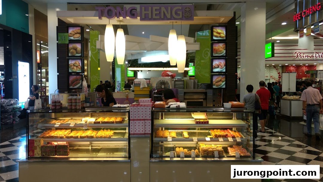 A bustling Tong Heng bakery stall in a mall, showcasing a variety of traditional Chinese pastries in display cases.