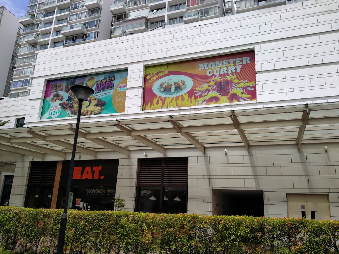 Exterior view of a building featuring large food advertisements for Hongdae Oppa and Monster Curry, with an 'EAT.' shop entrance.