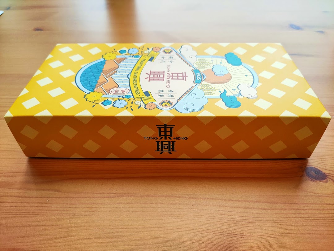 A vibrant yellow Tong Heng gift box featuring traditional Cantonese pastry branding.