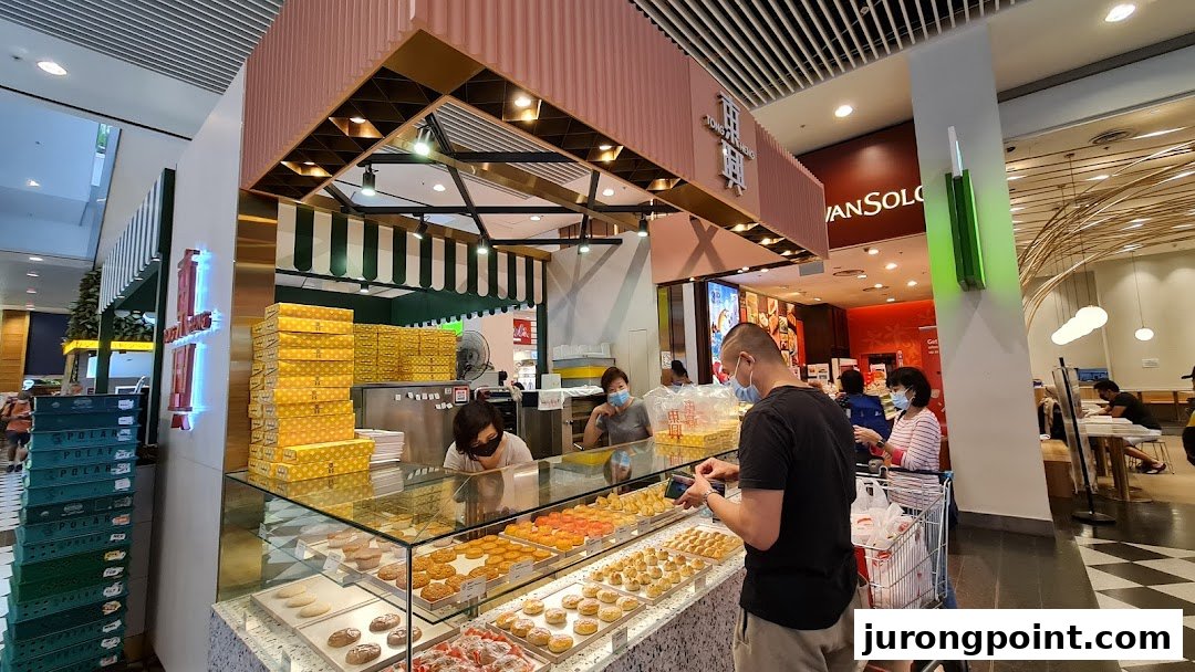 A bustling pastry shop counter showcasing a variety of traditional Chinese baked goods and pastries.