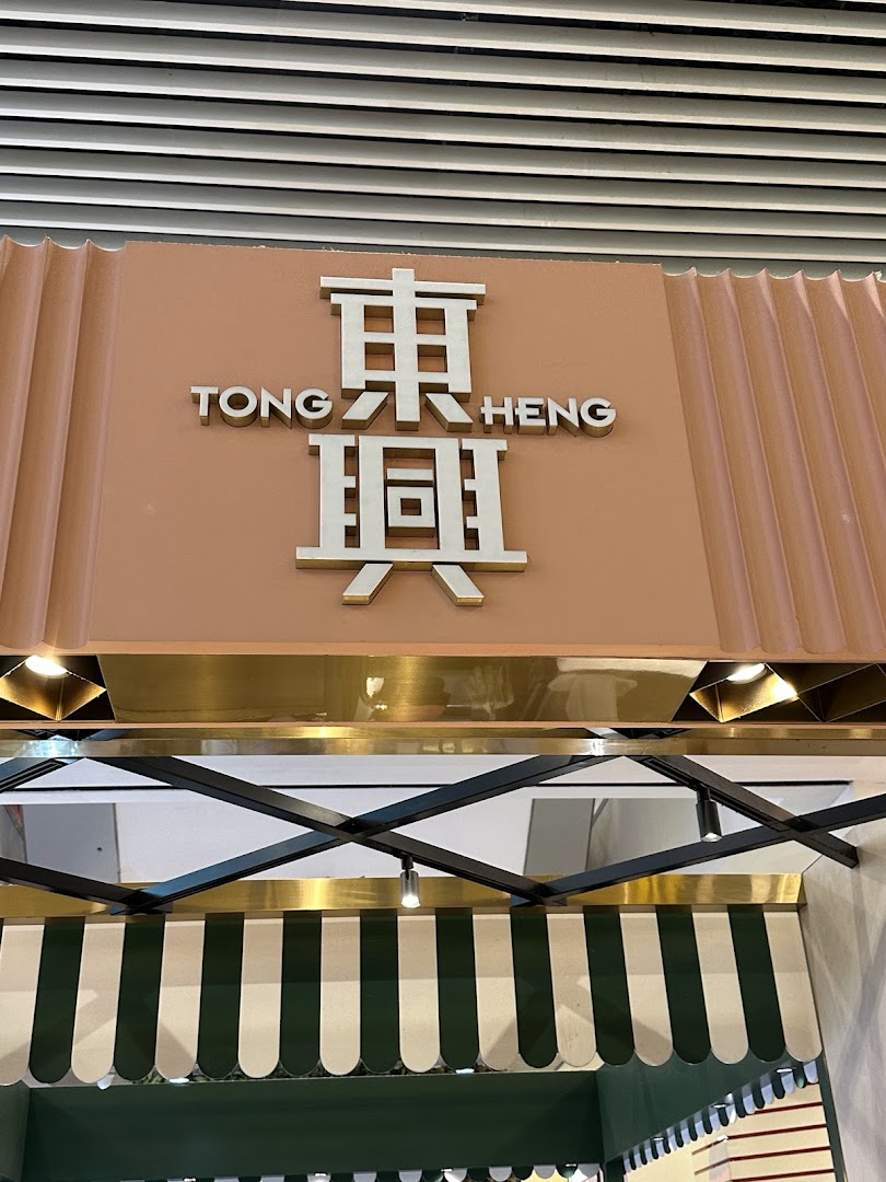 The shopfront of Tong Heng bakery, featuring its distinctive signage and green-striped awning.