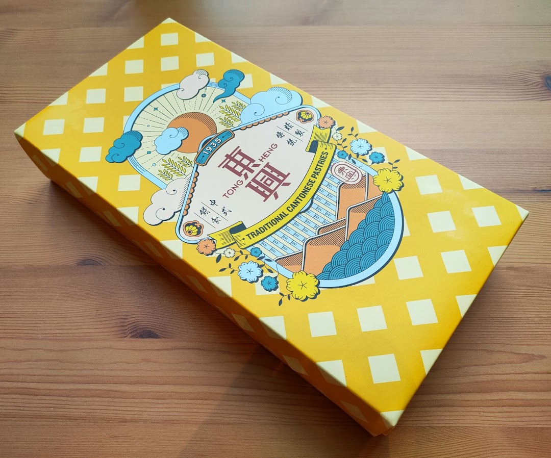 A vibrant yellow gift box from Tong Heng, featuring traditional Cantonese pastries.