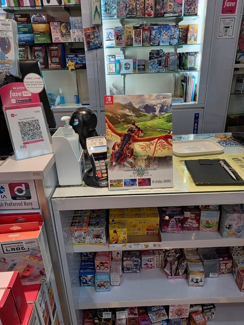 A retail counter displaying a variety of video games, trading cards, and collectible merchandise.