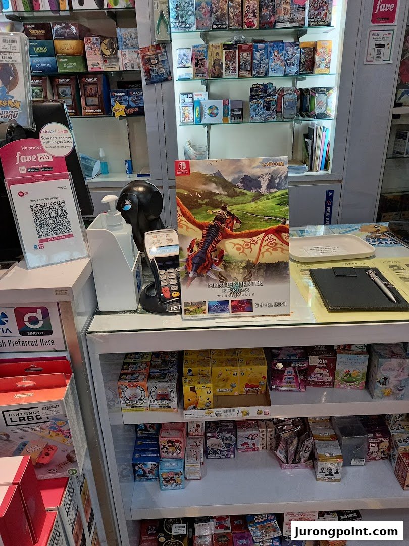 A retail counter displaying a variety of video games, trading cards, and collectible merchandise.