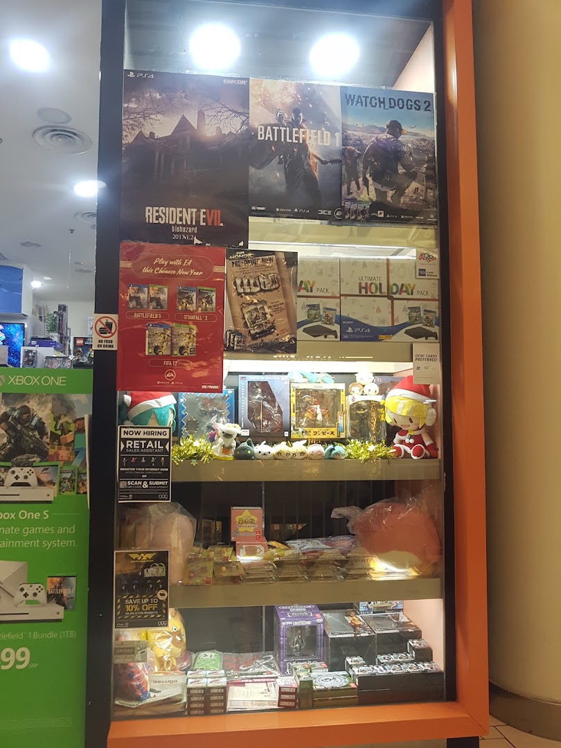 A brightly lit display case showcasing video game posters, console bundles, and various gaming merchandise.