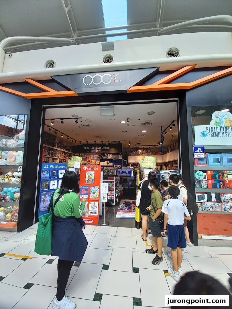 The shop front of Toy Or Game (TOG) with customers queuing to enter, showcasing gaming consoles and merchandise.