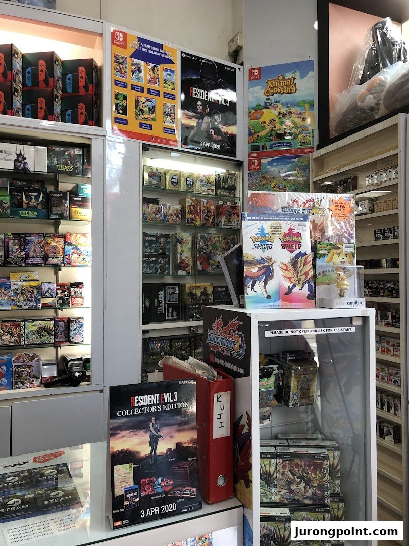 An interior view of a game and toy shop, showcasing video games, trading cards, and collectibles on display.