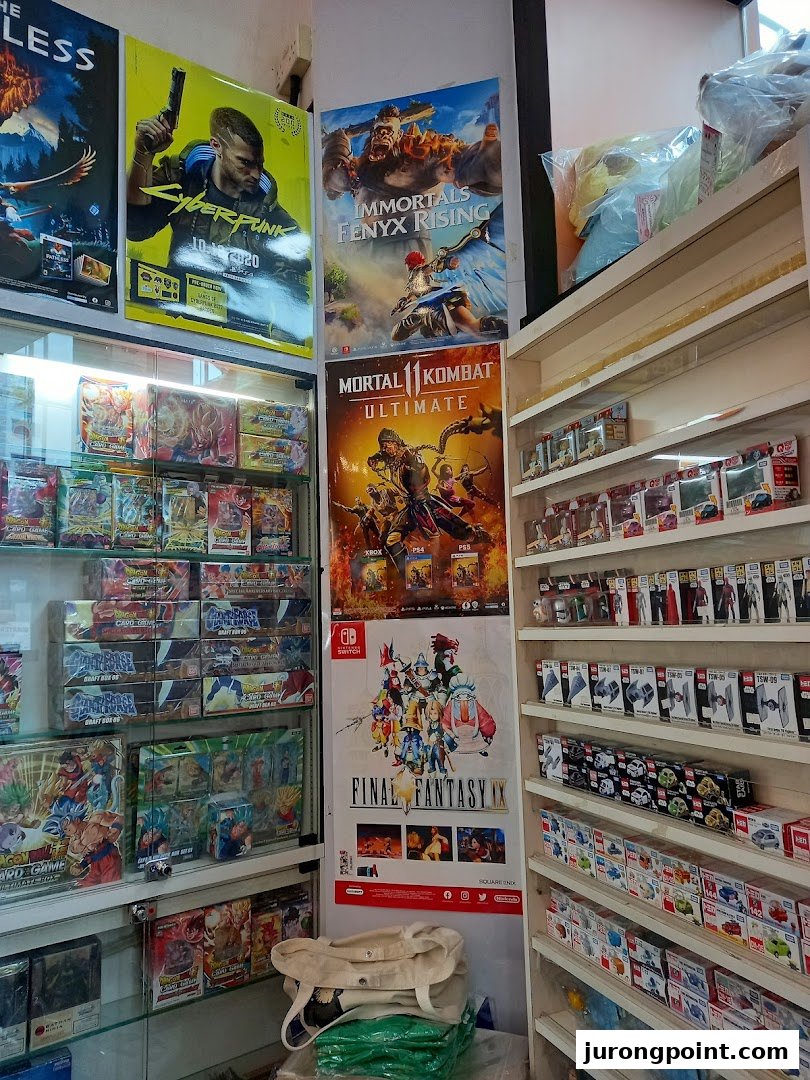 An interior view of a toy and game shop, featuring video game posters, trading card games, and collectible figures.