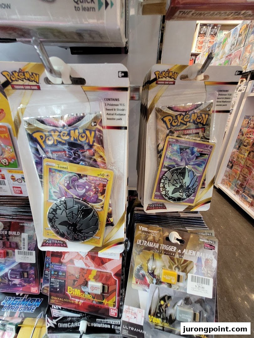 Close-up of Pokémon Trading Card Game and Ultraman merchandise displayed on shelves inside the store.