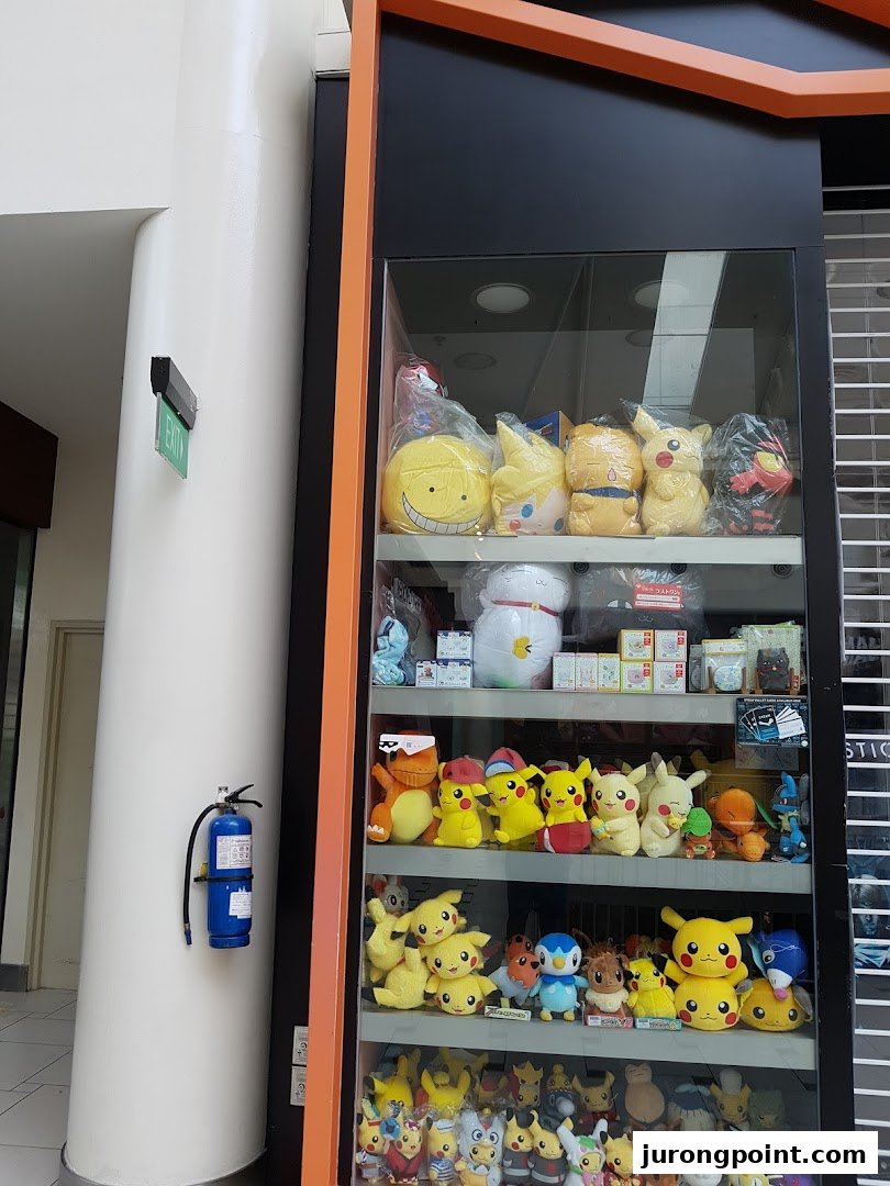 A vibrant display case showcasing a wide array of plush toys, including many popular Pokémon characters.