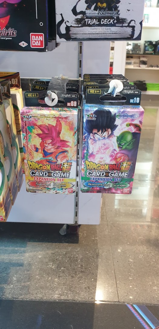 Close-up of Dragon Ball Super Card Game expansion sets and a Trial Deck+ on display.