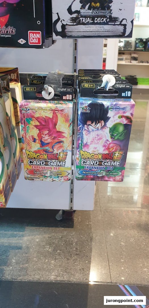 Close-up of Dragon Ball Super Card Game expansion sets and a Trial Deck+ on display.