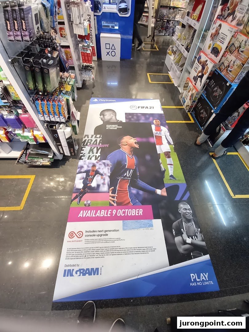 Interior view of a Toy Or Game TOG store featuring a large FIFA 21 floor advertisement and product shelves.