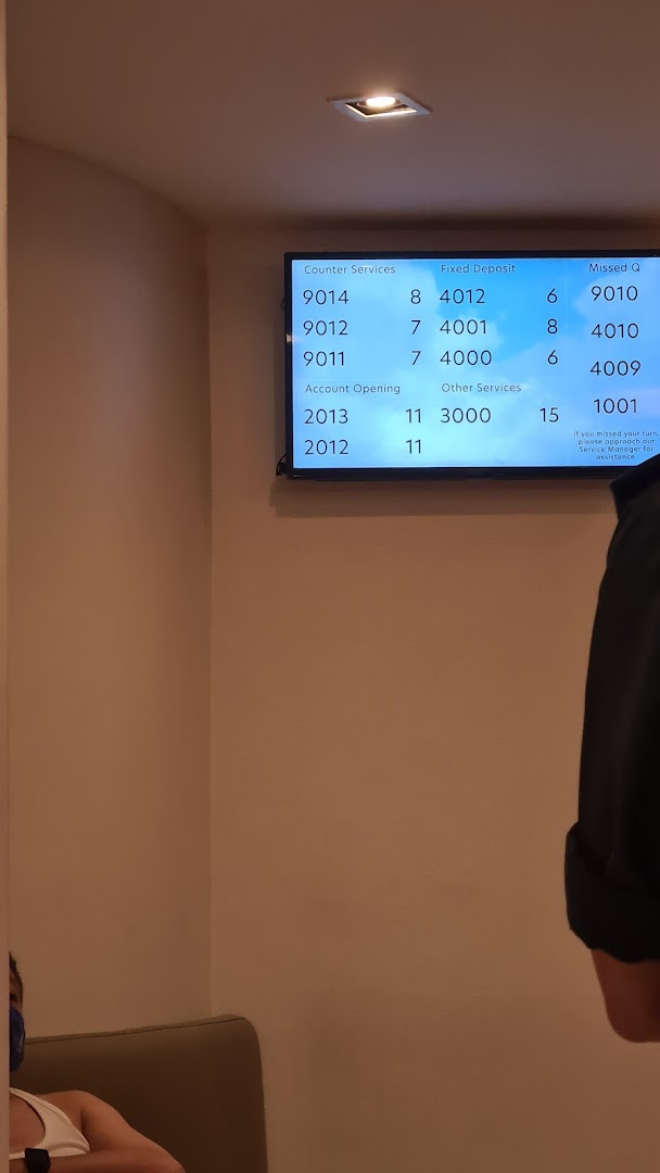 A digital queue management screen displaying service numbers at a bank branch.