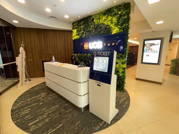 Modern interior of UOB Jurong Point branch with reception desk and Q-ticket system.